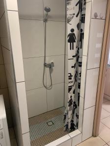W łazience znajduje się prysznic z czarno-białą zasłoną prysznicową. w obiekcie B&B vis a vis Zamku w mieście Malbork