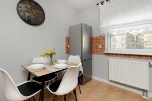een eetkamer met een tafel en stoelen en een klok bij Apartment in Gdańsk with 3 Bedrooms, Furnished Balcony and 2 Desks by Rent like home in Gdańsk