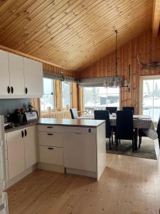 a kitchen and dining room with a table and chairs at Beautiful cabin close to activities in Trysil, Trysilfjellet, with Sauna, 4 Bedrooms, 2 bathrooms and Wifi in Trysil