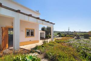 una casa blanca con un patio con flores en Casa Pimenta Rosa, en Alvor