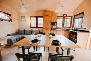 a kitchen and dining room with a table and chairs at WYPOCZYWANKO DOMEK PIERWSZA LINIA BRZEGOWA in Borsk