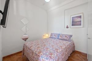 um quarto com uma cama num quarto branco em Apartamento frente a la playa em Málaga