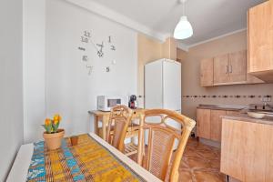 a kitchen with a table and chairs and a white refrigerator at Apartamento frente a la playa in Málaga