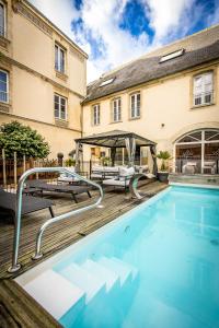 a swimming pool in front of a building at Grand Hôtel du Luxembourg & Spa in Bayeux