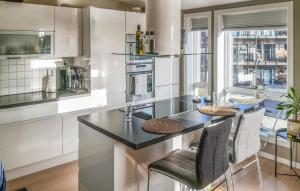 a kitchen with a counter with chairs and a stove at Lovely Home In Kristiansand S With House A Panoramic View in Kristiansand