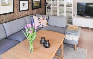een woonkamer met een bank en een tafel met bloemen bij Lovely Home In Kristiansand S With House A Panoramic View in Kristiansand