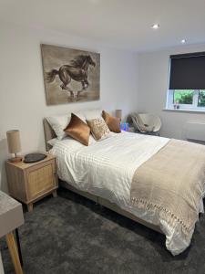 a bedroom with a bed with a horse painting on the wall at Poppy Lodge faversham in Boughton Street