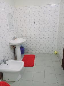 a white bathroom with a sink and a red rug at Peace N Quiet aux Almadies in Dakar +7 photos