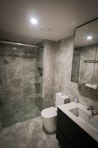 y baño con ducha, aseo y lavamanos. en Braddon 1BR Apt, WiFi, Secure Parking, AMAZING LOCATION en Canberra