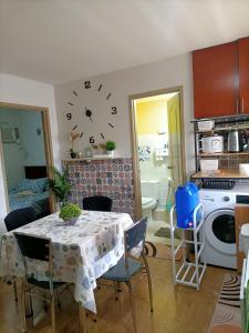 2 BR Sorrento Oasis في مانيلا: مطبخ مع طاولة وساعة على الحائط