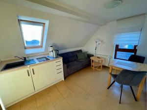 a kitchen and living room with a couch and a table at BORKUMUNTERKUNFT - WOH2 - IM HERZEN DER INSEL in Borkum