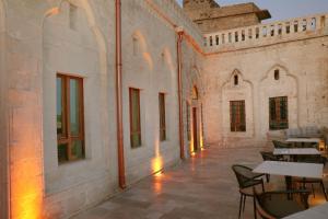 an empty patio with tables and chairs in a building at Zabel Hotel in Mardin