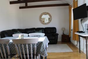 sala de estar con mesa y sofá negro en New Listing - Idyllic cottage in a beautiful Kent setting, en Kent