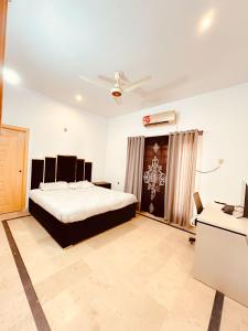 a bedroom with a bed and a desk in it at QueensLand villa near Islamabad airport & motorway in Rawalpindi