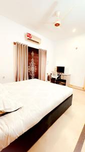a large white bed in a room with a desk at QueensLand villa near Islamabad airport & motorway in Rawalpindi