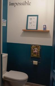 a bathroom with a toilet and a blue wall at Nawenn locations - maison du bonheur in La Landec