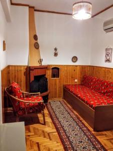 Habitación con sofá rojo y 2 sillas en Zenios Alexandros - Traditional penthouse, en Oia