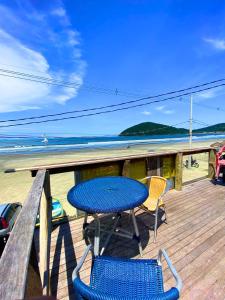 een blauwe tafel en stoelen op een terras met het strand bij Restaurante e Pousada - Ilha Bonita in Guarujá