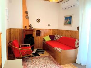 a living room with a red couch and a fireplace at Zenios Alexandros - Traditional penthouse in Oia