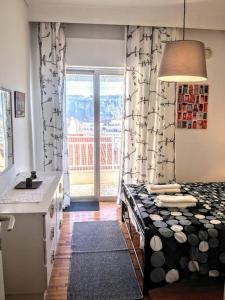 a room with a kitchen with a bed and a window at Zenios Alexandros - Traditional penthouse in Oia