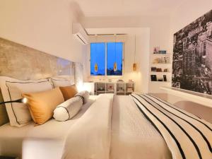 1 dormitorio con 1 cama grande con almohadas y ventana en Epic Design: Unforgettable Stay, en Linda-a-Velha