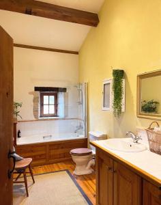 a bathroom with a tub and a toilet and a sink at Les Hauts de Broze in Broze