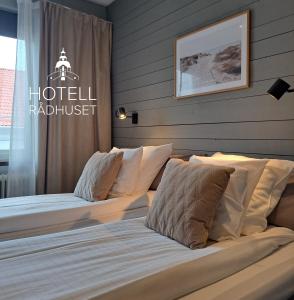 two beds in a bedroom with a hotel radiologist sign at Hotell Rådhuset in Lidköping