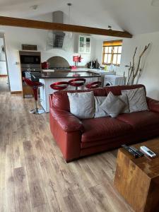sala de estar con sofá rojo y cocina en Stable lodge 2 Bedrooms, en Horspath