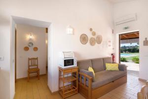 a living room with a couch and a microwave at Casa Laranja Canela in Alvor