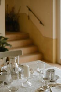 una mesa blanca con una vela y platos y vasos en Belcasale en Vignale