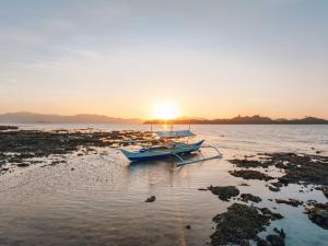 a boat sitting on the water at sunset at Sunset Colors in San Vicente