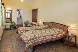 a bedroom with two beds and two tables at The Green Hotel in Mysore