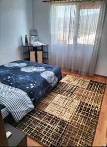 a bedroom with a bed and a large rug at Apartament Home Comfort in Orşova