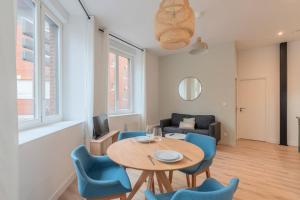 un salon avec une table, des chaises et un canapé dans l'établissement One bedroom apartment with parking, city center, à Tourcoing