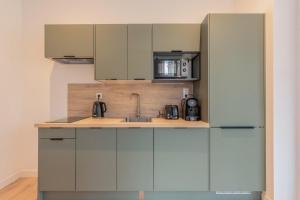 a kitchen with white cabinets and a sink at One bedroom apartment with parking, city center in Tourcoing