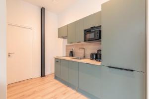 a kitchen with a sink and a refrigerator at One bedroom apartment with parking, city center in Tourcoing +10 photos