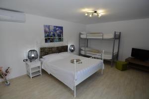 a bedroom with a bed and two bunk beds at Vila La Panda in Costinesti
