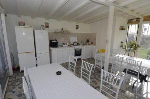 a kitchen with white appliances and a table and chairs at Vila La Panda in Costinesti
