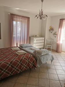 Schlafzimmer mit einem Bett, einer Kommode und einem Fenster in der Unterkunft Casa Vacanze Minula - Indipendent Country House in Carnello