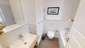 ペルツァーハケンにあるApartment Südkap C 05の洗面台とトイレを備えた白いバスルーム