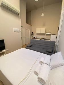 a room with two white beds and a kitchen at Studio in Barrio Salamanca (D) in Madrid