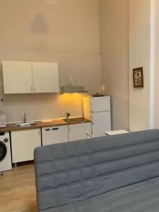 a kitchen with white cabinets and a couch in a room at Studio in Barrio Salamanca (D) in Madrid