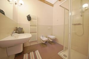 biała łazienka z umywalką i toaletą w obiekcie La Corte di Nonna Gemma - Holiday Home w mieście Delebio +37 zdjęć