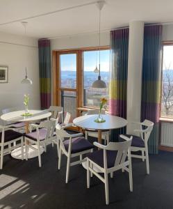 2 mesas y sillas en una habitación con ventanas en Svf Hotell & Konferens en Jönköping