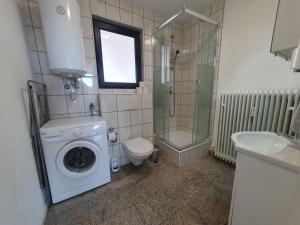 y baño con lavadora y lavamanos. en 1-Zimmer-Wohnung-EG Fewo 2 Rupertsberg, en St. Georgen im Schwarzwald