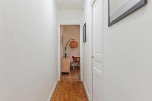 a hallway with a white door and a table at Cozy Parisian Retreat in the Heart of the City in Paris