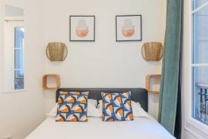 1 dormitorio con 1 cama y 3 cuadros en la pared en Cozy Parisian Retreat in the Heart of the City en París