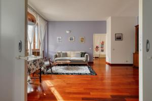 un soggiorno con divano e pavimento in legno di Ample Apartment with private parking a Milano