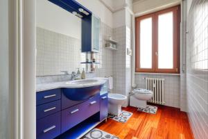 bagno con lavandino blu e servizi igienici di Ample Apartment with private parking a Milano