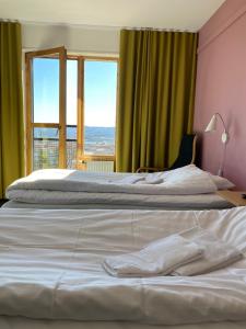 two beds in a room with two windows at Svf Hotell & Konferens in Jönköping